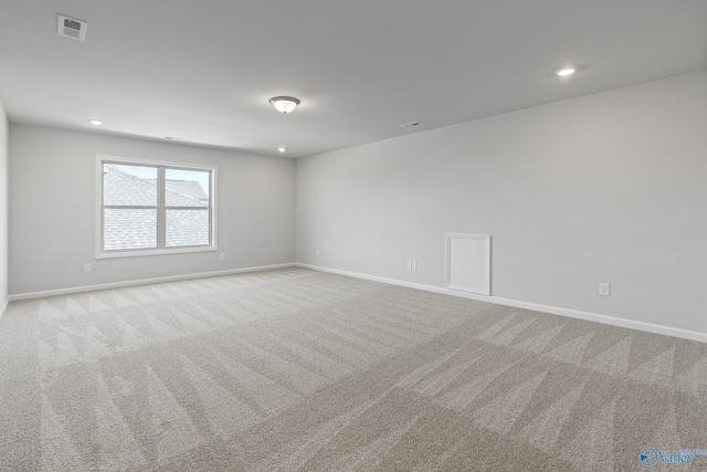 carpeted empty room featuring recessed lighting, visible vents, and baseboards