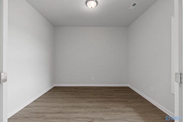 spare room featuring visible vents, baseboards, and wood finished floors