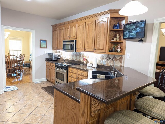 kitchen featuring a sink, decorative backsplash, light tile patterned flooring, open shelves, and appliances with stainless steel finishes