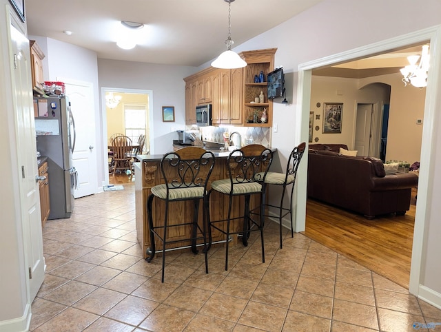 dining area featuring light tile patterned flooring and arched walkways