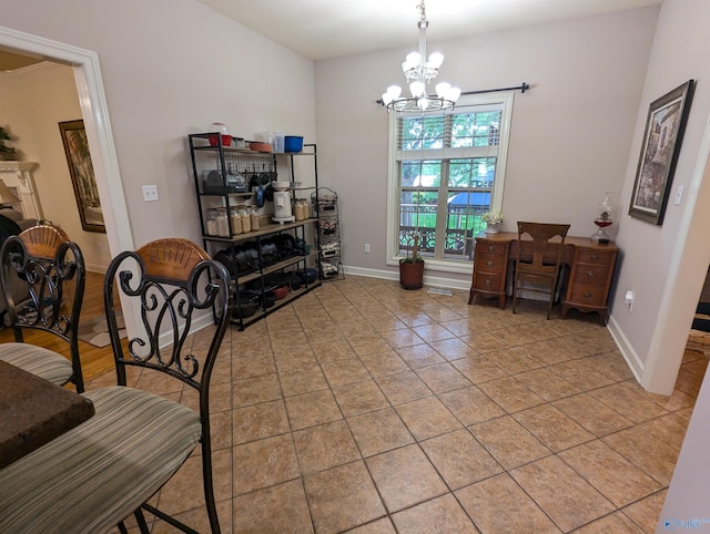 dining space featuring light tile patterned floors, a notable chandelier, and baseboards
