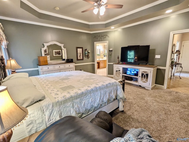 carpeted bedroom featuring tile patterned floors, ornamental molding, ensuite bathroom, baseboards, and a raised ceiling
