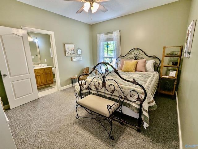 bedroom featuring light colored carpet, connected bathroom, a ceiling fan, and baseboards