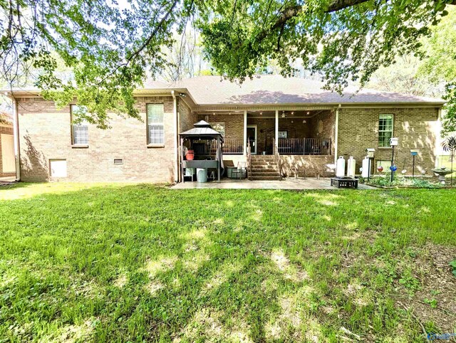 back of house with brick siding, a gazebo, a yard, and a patio area