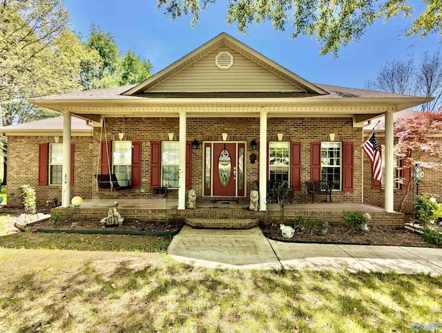 view of front of property featuring covered porch and brick siding