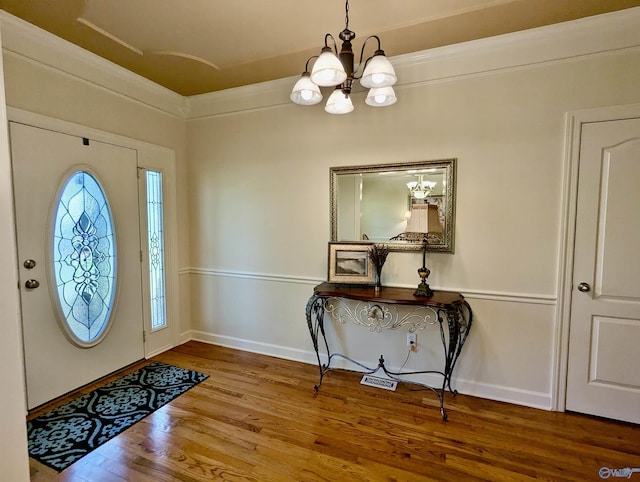 foyer entrance with a notable chandelier, wood finished floors, and baseboards