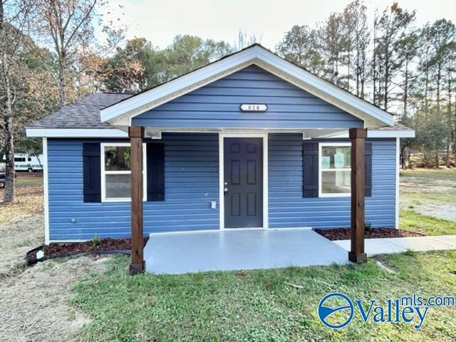 bungalow-style home featuring covered porch and a front yard