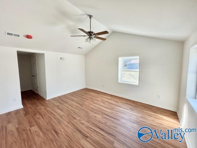 spare room featuring hardwood / wood-style flooring, ceiling fan, and lofted ceiling