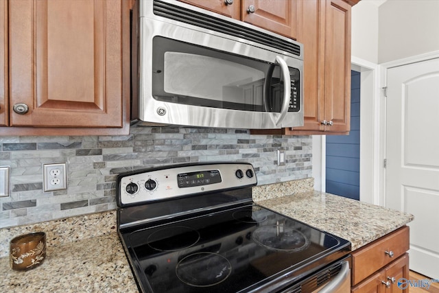 kitchen featuring light stone countertops, appliances with stainless steel finishes, and decorative backsplash