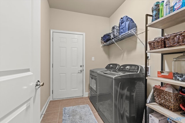 clothes washing area with light tile patterned flooring and independent washer and dryer