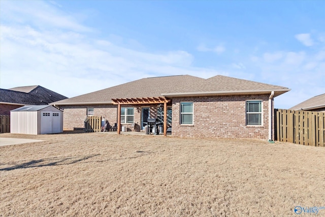 rear view of property with a pergola, a patio area, and a shed