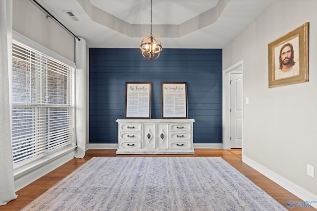 sitting room featuring a chandelier, light hardwood / wood-style floors, and a tray ceiling