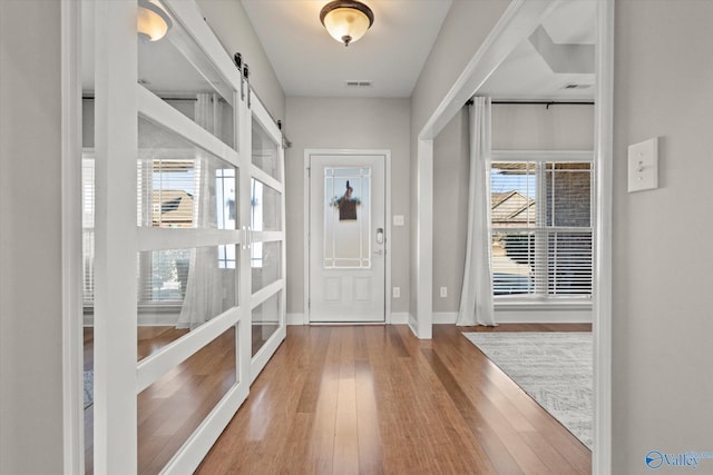 foyer with hardwood / wood-style flooring and a barn door