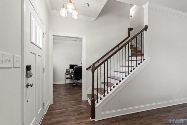 foyer entrance featuring an inviting chandelier, crown molding, and dark hardwood / wood-style floors