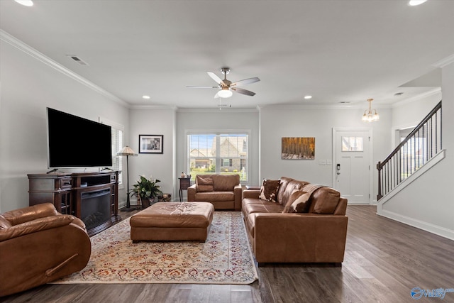 living room with ceiling fan with notable chandelier, dark hardwood / wood-style floors, and ornamental molding