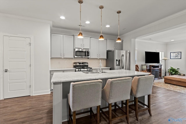 kitchen featuring pendant lighting, a center island with sink, stainless steel appliances, a breakfast bar, and dark hardwood / wood-style flooring