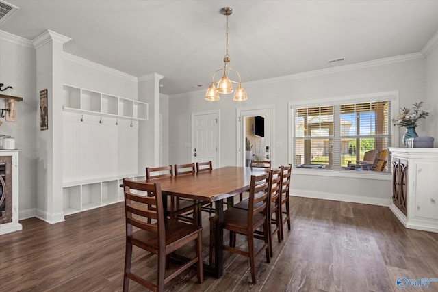 dining space featuring crown molding, a fireplace, an inviting chandelier, and dark wood-type flooring