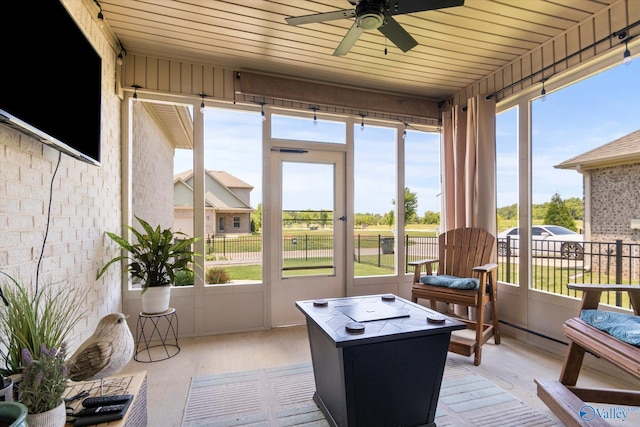 sunroom / solarium with ceiling fan and wood ceiling