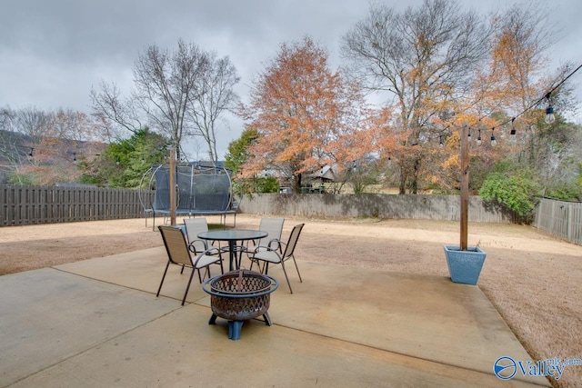 view of patio / terrace with an outdoor fire pit and a trampoline