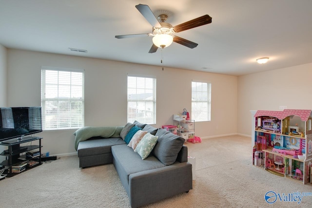 carpeted living room featuring plenty of natural light and ceiling fan