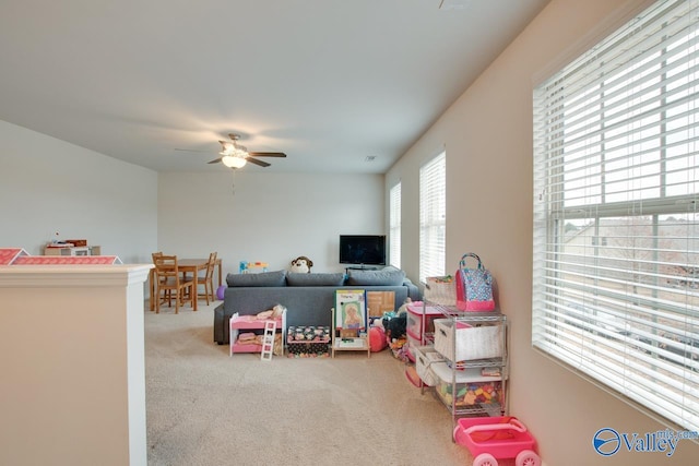 recreation room with ceiling fan and carpet