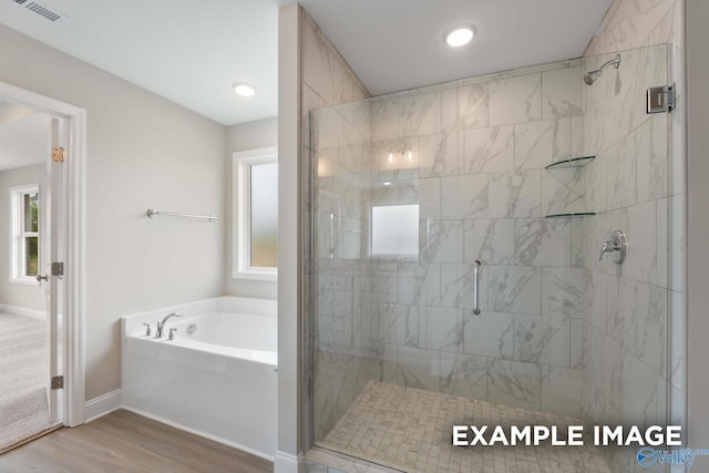 full bath with a garden tub, visible vents, a shower stall, wood finished floors, and baseboards