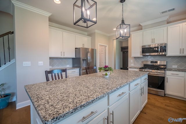 24337 Beacon Cir, Athens, AL 35613 - kitchen with appliances with stainless steel finishes, a center island, crown molding, tasteful backsplash, and white cabinets