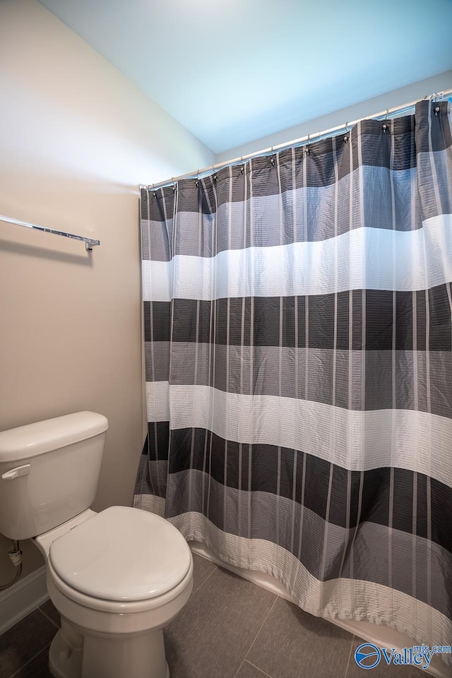 24337 Beacon Cir, Athens, AL 35613 - bathroom with toilet, tile patterned flooring, vaulted ceiling, and a shower with shower curtain