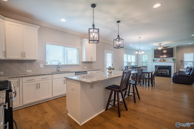 24337 Beacon Cir, Athens, AL 35613 - kitchen featuring stainless steel appliances, ornamental molding, white cabinets, a center island, and wood finished floors
