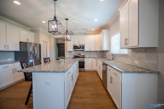 24337 Beacon Cir, Athens, AL 35613 - kitchen featuring stainless steel appliances, a sink, white cabinetry, a kitchen island, and crown molding