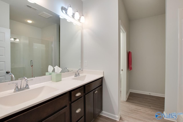 bathroom featuring a shower with shower door, vanity, and wood-type flooring