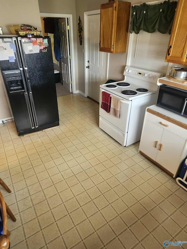 2505 E Broad St, Gadsden, AL 35905 - kitchen with black appliances, brown cabinetry, light tile patterned floors, and baseboards