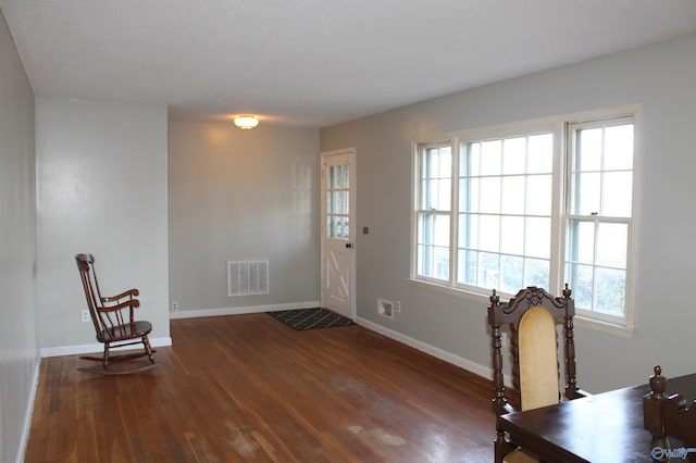 foyer with dark wood finished floors, visible vents, and baseboards