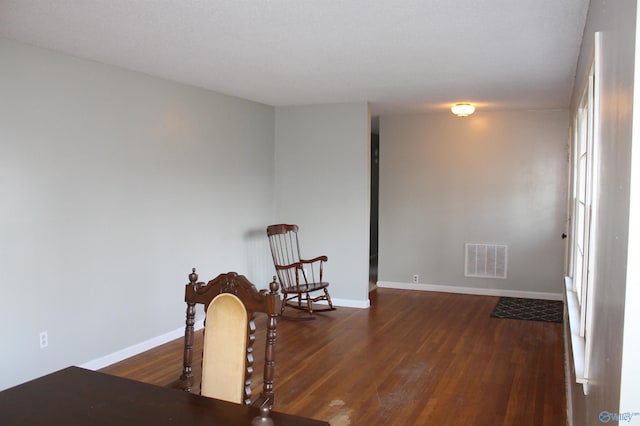 sitting room with dark wood-type flooring