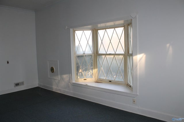 unfurnished room featuring visible vents, baseboards, and ornamental molding