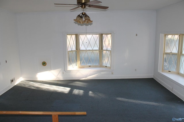 empty room featuring visible vents, baseboards, carpet floors, ornamental molding, and a ceiling fan