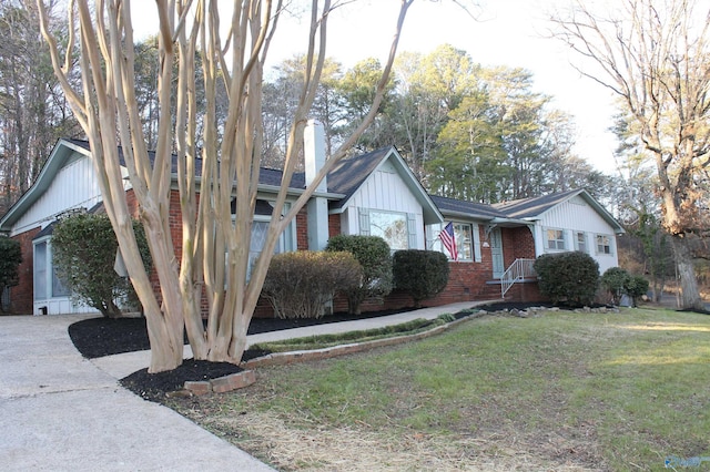 single story home featuring driveway, a chimney, a front lawn, crawl space, and brick siding