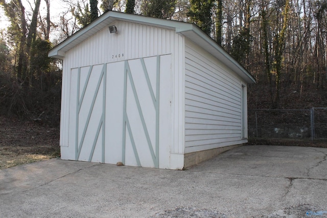 view of outdoor structure featuring an outbuilding and fence