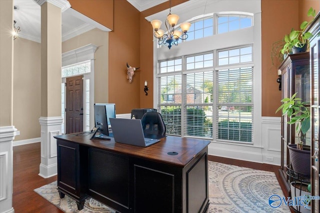 office space featuring a towering ceiling, a notable chandelier, dark hardwood / wood-style floors, and crown molding