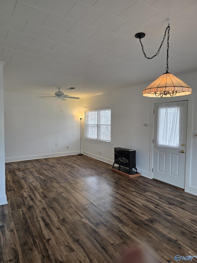 unfurnished living room with ceiling fan, baseboards, dark wood finished floors, and a wood stove