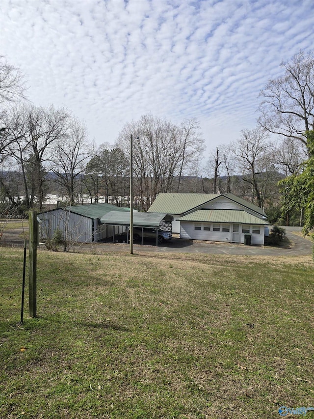 view of front of home with metal roof and a front lawn