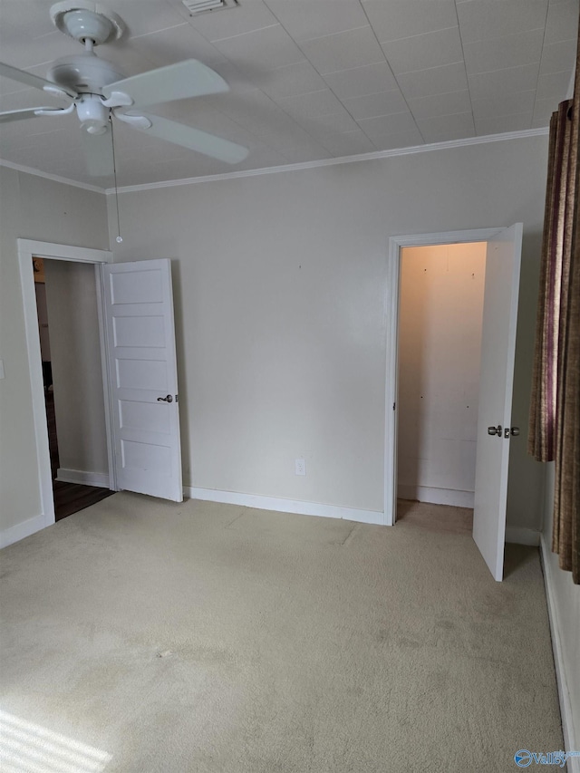 unfurnished bedroom with crown molding, carpet, baseboards, and visible vents