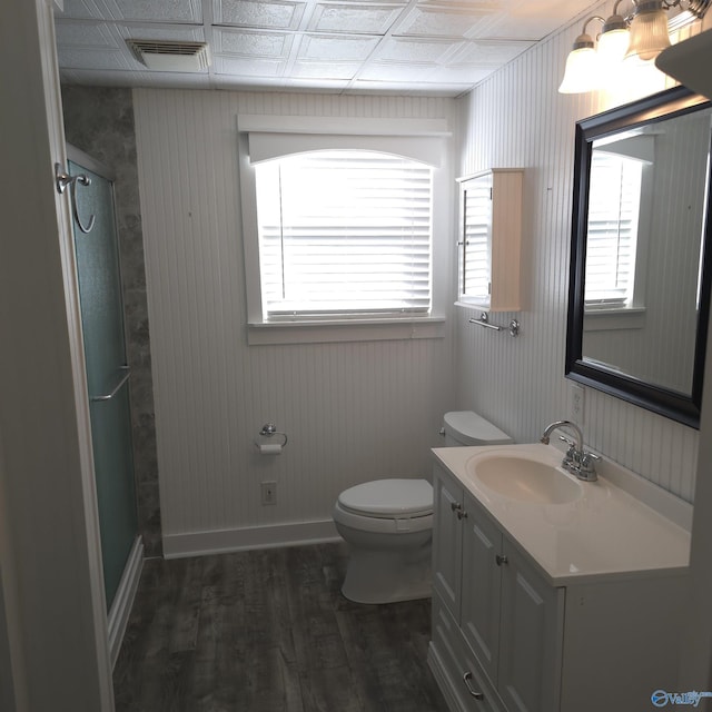 full bath with visible vents, toilet, wood finished floors, a shower stall, and vanity