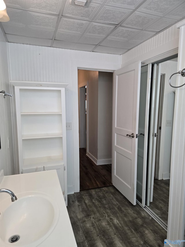 bathroom with wood finished floors, an ornate ceiling, and a sink