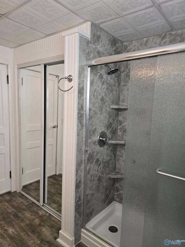 full bathroom with a shower stall, an ornate ceiling, and wood finished floors