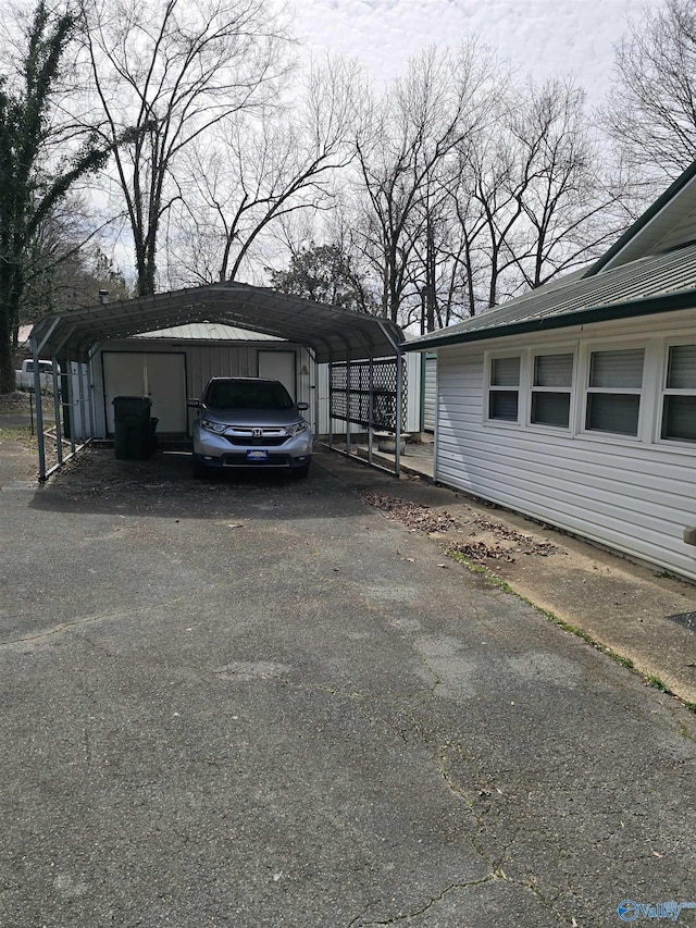 view of parking / parking lot featuring a detached carport and driveway