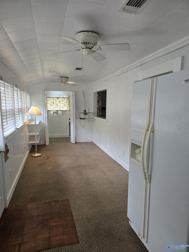 interior space with lofted ceiling, carpet flooring, visible vents, and ceiling fan