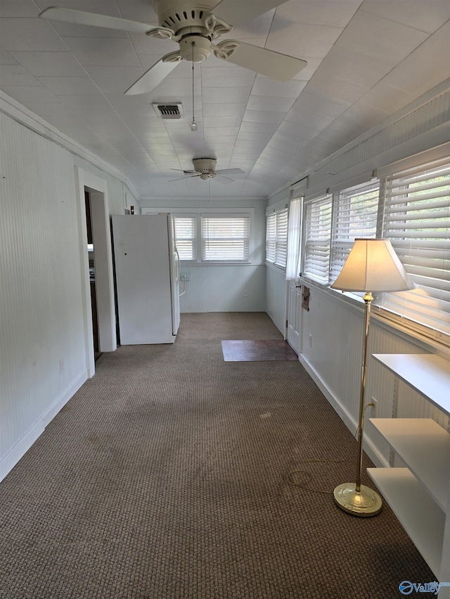 spare room with visible vents, a ceiling fan, and carpet floors