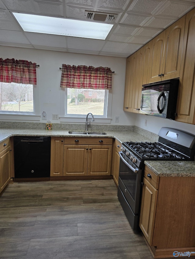 kitchen featuring black appliances, plenty of natural light, visible vents, and a sink