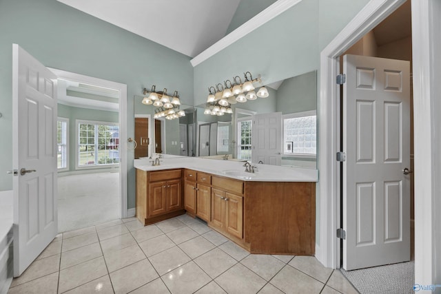 bathroom featuring tile patterned flooring, a sink, lofted ceiling, and double vanity